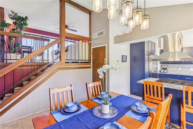 dining space featuring ceiling fan with notable chandelier and light tile patterned floors