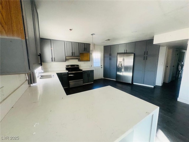 kitchen with pendant lighting, gray cabinets, kitchen peninsula, and appliances with stainless steel finishes