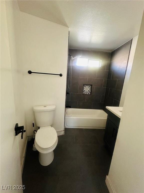 full bathroom with tiled shower / bath, vanity, and toilet