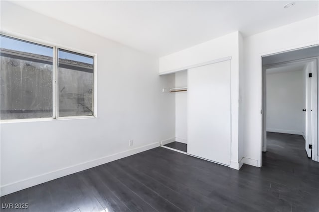 unfurnished bedroom featuring dark wood-type flooring and a closet