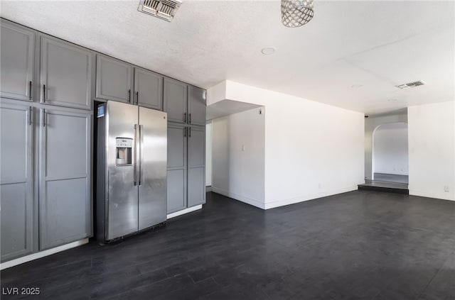 kitchen featuring gray cabinets, a textured ceiling, and stainless steel fridge with ice dispenser