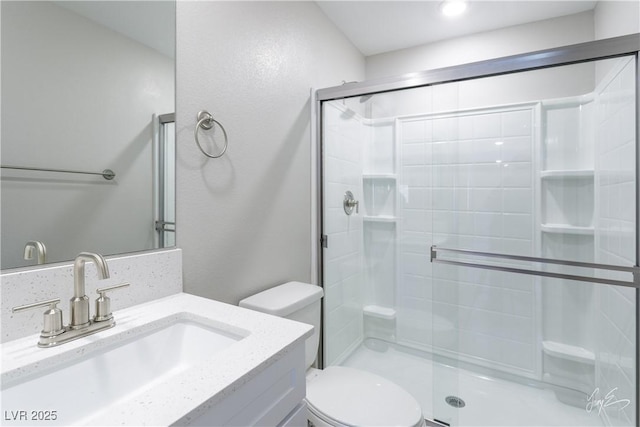 bathroom with an enclosed shower, vanity, and toilet