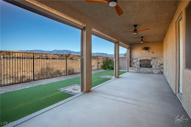 view of patio / terrace featuring ceiling fan and a mountain view