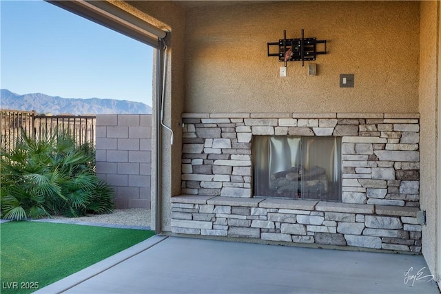 exterior space featuring a mountain view and an outdoor stone fireplace