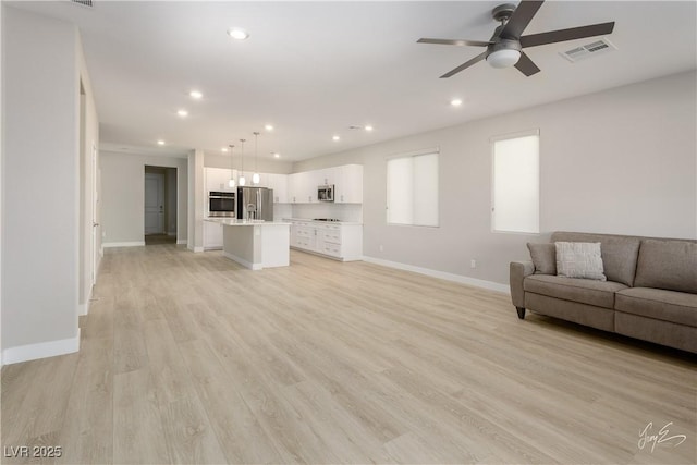 unfurnished living room featuring ceiling fan and light wood-type flooring