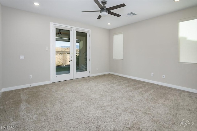 carpeted empty room featuring french doors and ceiling fan