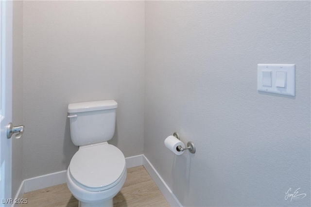 bathroom with hardwood / wood-style floors and toilet