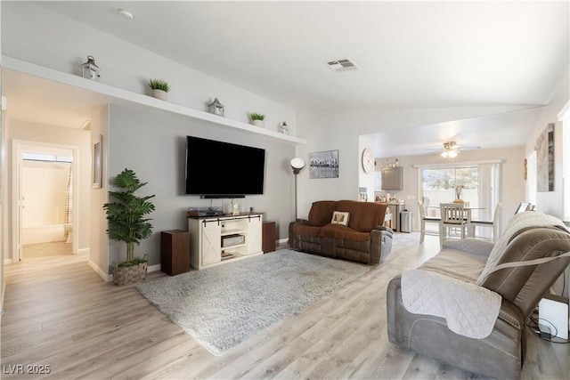 living room featuring lofted ceiling, ceiling fan, and light wood-type flooring