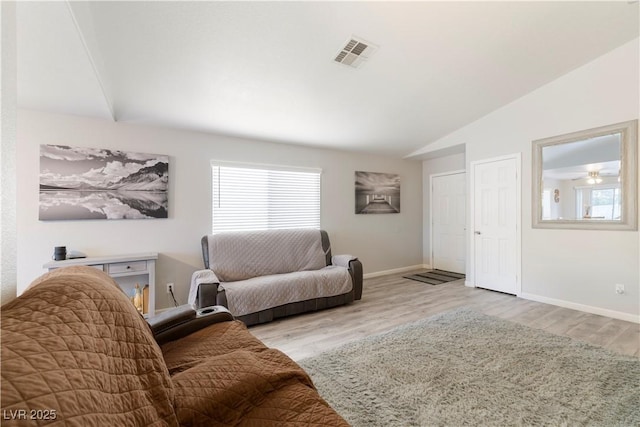 living room featuring lofted ceiling and light wood-type flooring