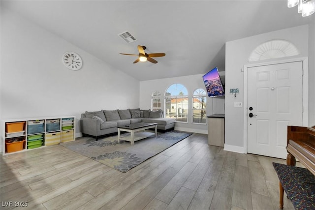 living room with lofted ceiling, ceiling fan, and light wood-type flooring