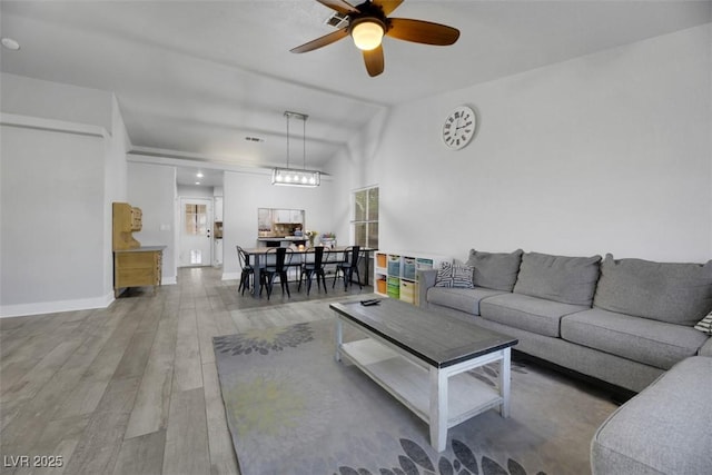 living room with hardwood / wood-style flooring, lofted ceiling, and ceiling fan