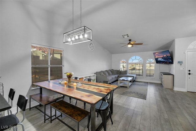 dining room with wood-type flooring, ceiling fan, and vaulted ceiling