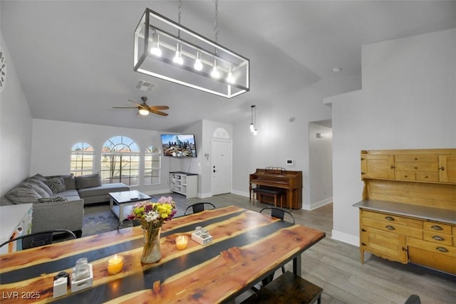 dining space featuring vaulted ceiling, ceiling fan, and light hardwood / wood-style floors