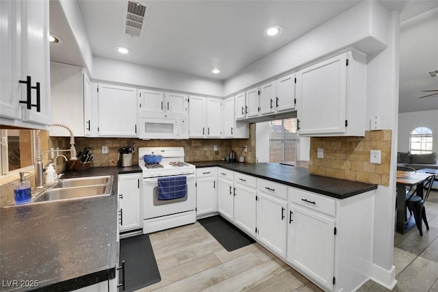 kitchen with white cabinetry, sink, white appliances, and backsplash