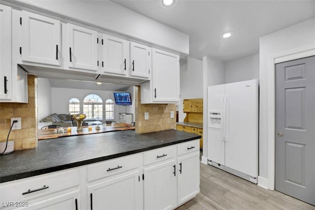 kitchen with white cabinetry, white fridge with ice dispenser, backsplash, and light wood-type flooring