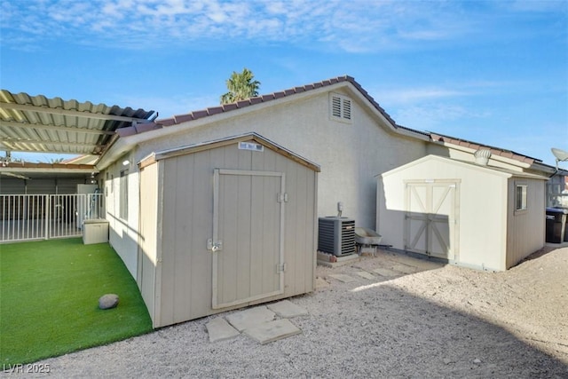 view of outdoor structure with central AC and a pergola