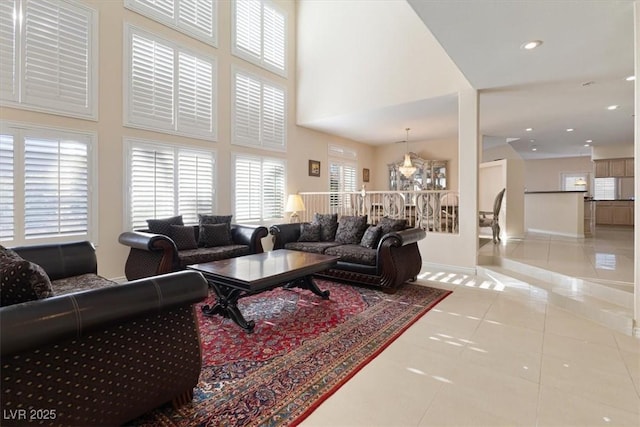 living room featuring light tile patterned floors and a towering ceiling