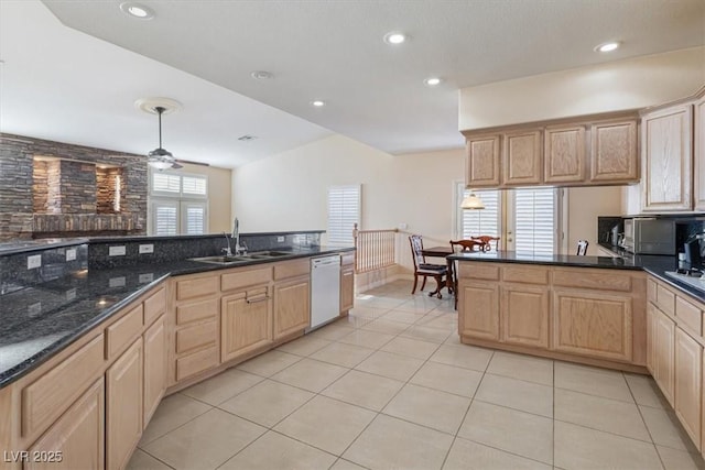 kitchen featuring sink, dishwasher, light tile patterned flooring, light brown cabinetry, and dark stone counters