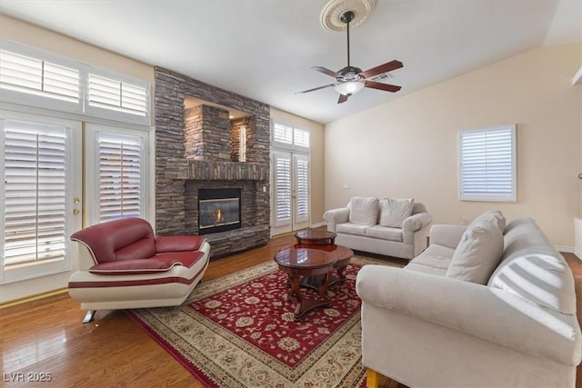 living room with lofted ceiling, hardwood / wood-style flooring, a fireplace, and ceiling fan