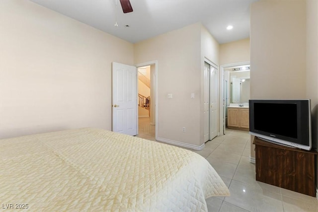 bedroom featuring light tile patterned floors, ensuite bath, a closet, and ceiling fan