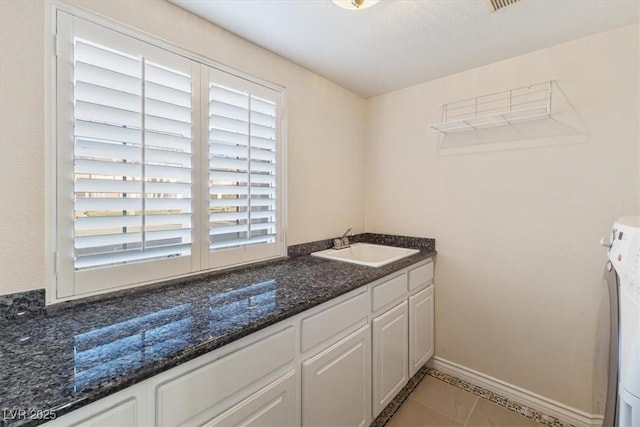 bathroom with tile patterned floors, washer / clothes dryer, vanity, and a wealth of natural light