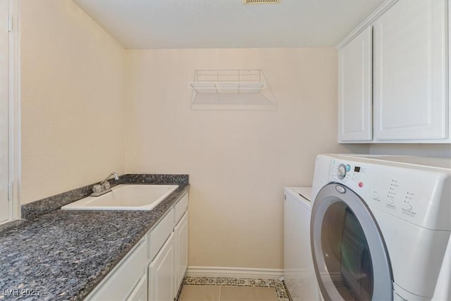 laundry room featuring sink, light tile patterned floors, washer and clothes dryer, and cabinets