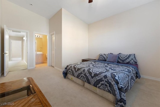 carpeted bedroom with connected bathroom, high vaulted ceiling, and ceiling fan