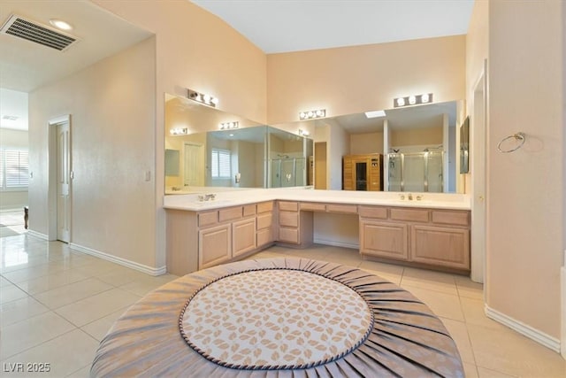 bathroom featuring vanity, a shower with shower door, and tile patterned flooring