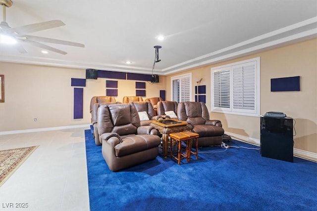 cinema room featuring ceiling fan and a tray ceiling