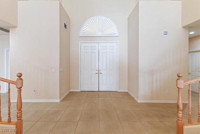 tiled entryway with a towering ceiling