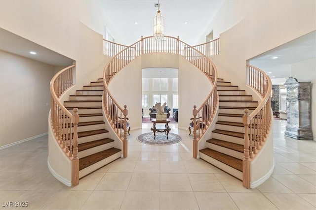 tiled entryway featuring a high ceiling and a chandelier