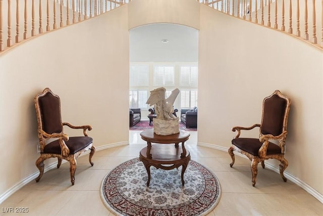 sitting room with a high ceiling and light tile patterned flooring