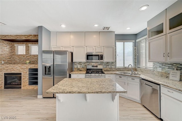 kitchen featuring white cabinetry, appliances with stainless steel finishes, sink, and a kitchen island