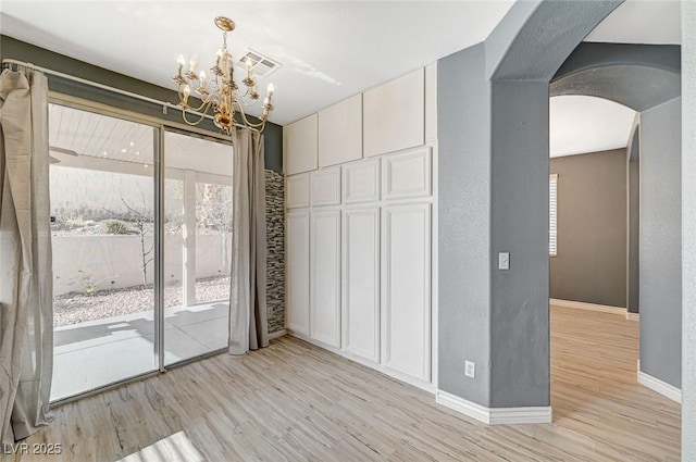 interior space featuring an inviting chandelier, access to outside, and light wood-type flooring