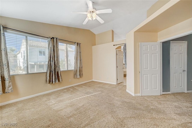 unfurnished bedroom with ceiling fan, vaulted ceiling, and light carpet