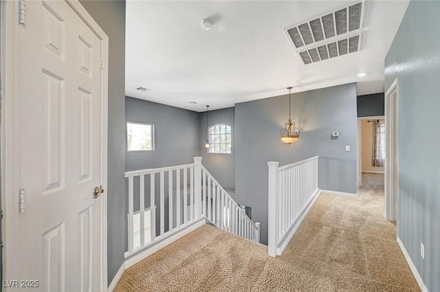 hallway featuring light colored carpet