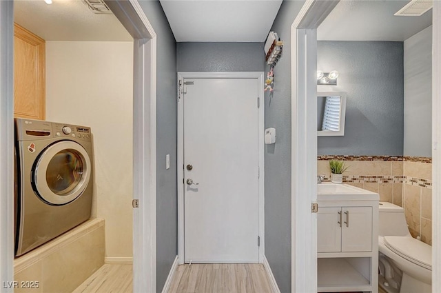 interior space featuring washer / dryer and tile walls