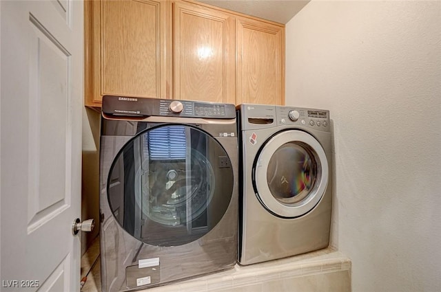 laundry area with cabinets and washer and clothes dryer