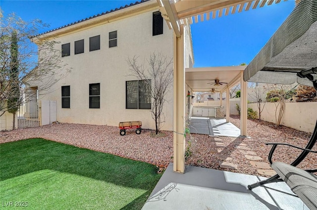 rear view of property featuring a patio area and ceiling fan