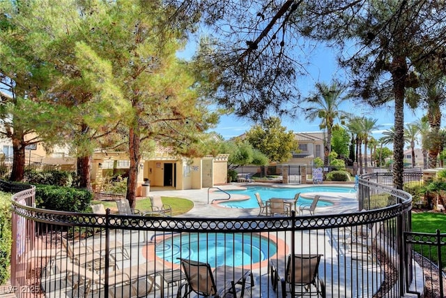 view of pool with a hot tub and a patio area