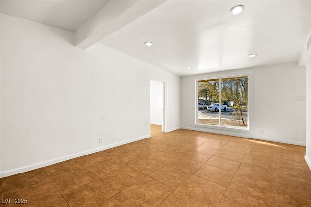 tiled empty room featuring beam ceiling