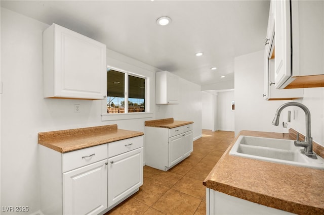 kitchen with white cabinetry, sink, and light tile patterned floors