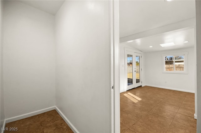 hall with tile patterned flooring, lofted ceiling, and french doors