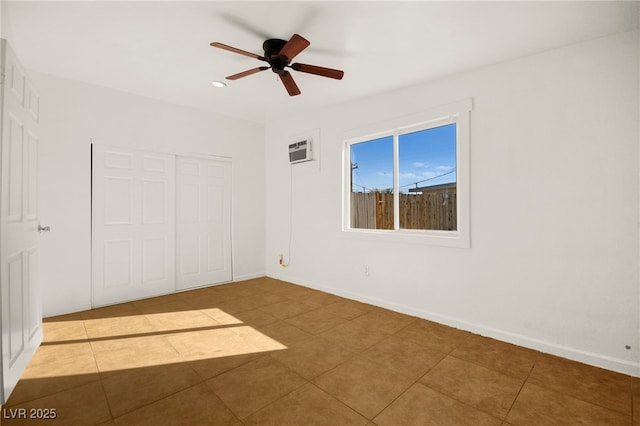 unfurnished bedroom featuring a wall mounted AC, tile patterned floors, ceiling fan, and a closet