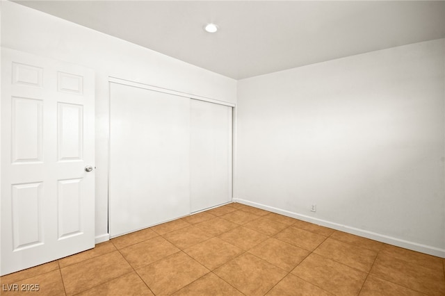 unfurnished bedroom featuring light tile patterned floors and a closet