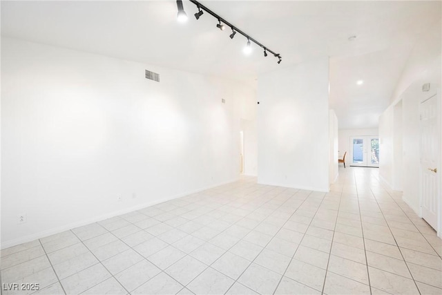 spare room featuring light tile patterned flooring and track lighting