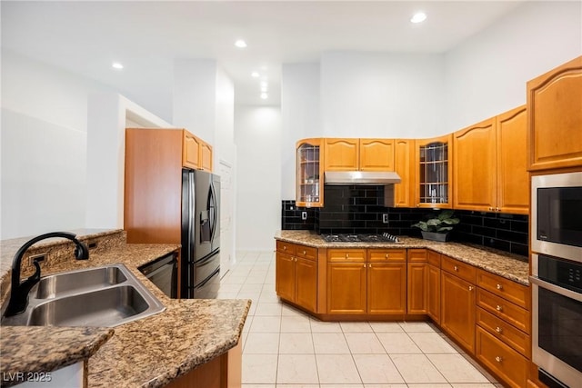 kitchen featuring a high ceiling, light tile patterned flooring, sink, and black appliances