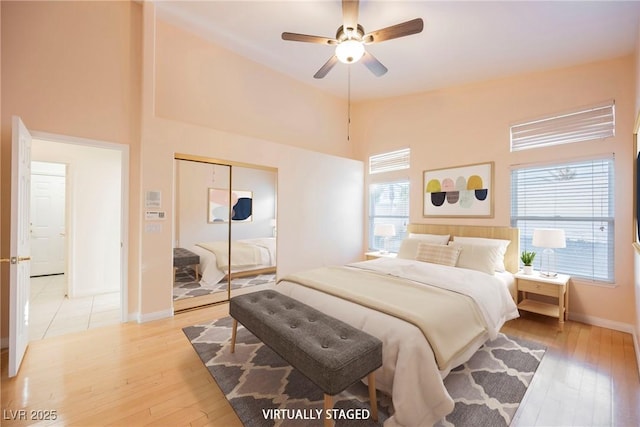 bedroom with ceiling fan, a closet, and light hardwood / wood-style flooring