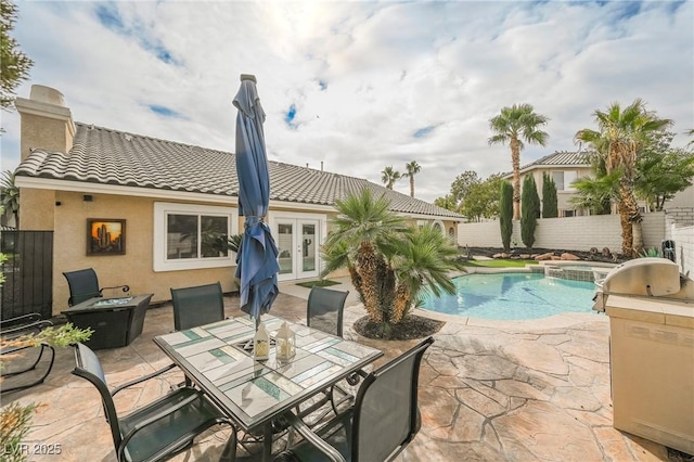 view of pool featuring a patio, an in ground hot tub, and french doors