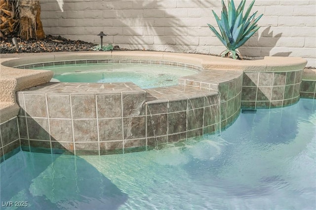 view of pool featuring an in ground hot tub